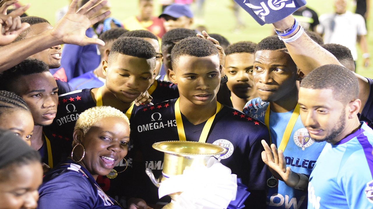 Jamaica College players get ready to hoist the Manning Cup after defeating St Andrew Technical High School in the finals at the National Stadium on Friday, December 1. (PHOTOS: Marlon Reid)