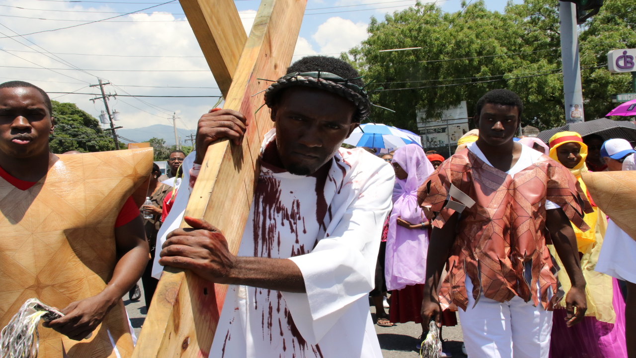 Jonathan Ononiwu carries the wooden cross during the Holy Cross Roman Catholic Church’s annual crucifixion re-enactment on Good Friday. (PHOTOS: Llewellyn Wynter)