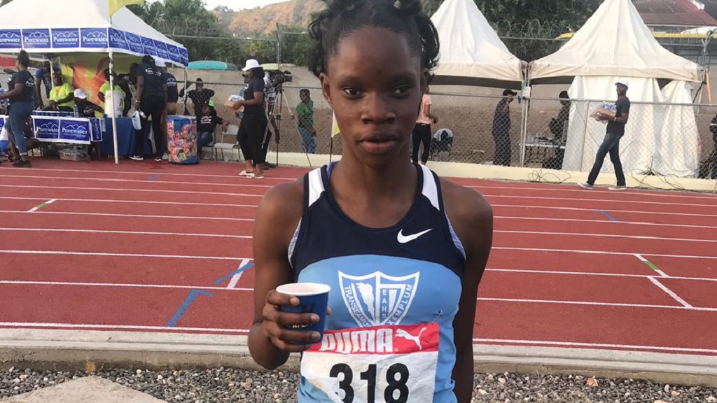 Tia Clayton of Edwin Allen (AA) defeats Oneka Wilson of Hydel (AB) on the  anchor of the Championship of America girls 4 x 100m relay, meet record  43.18 to 43.69, during the