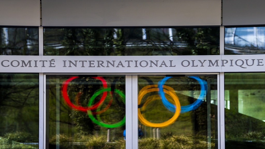 The Olympic Rings are displayed at the entrance of the IOC, International Olympic Committee headquarters during the coronavirus disease (COVID-19) outbreak in Lausanne, Switzerland, Tuesday, March 24, 2020. (Jean-Christophe Bott/Keystone via AP).