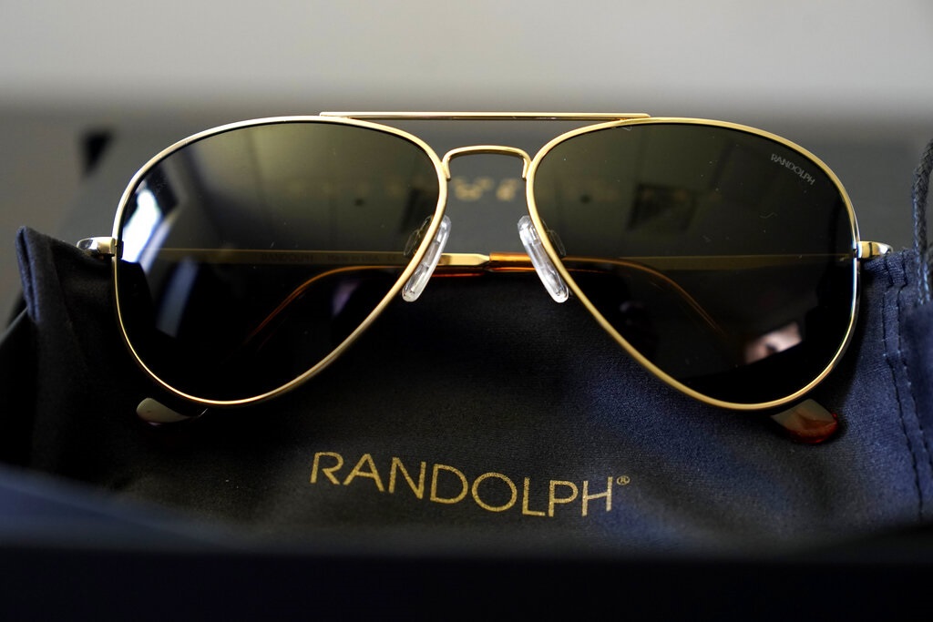 A pair of Randolph Engineering Concorde teardrop sunglasses, in 23-karat gold finish with polarized American gray lenses, rest on a table at the company where they are made, in Randolph, Mass., Thursday, June 17, 2021. Russian President Vladimir Putin received a pair of the sunglasses from President Joe Biden following their meeting in Switzerland this week. (AP Photo/Steven Senne)

