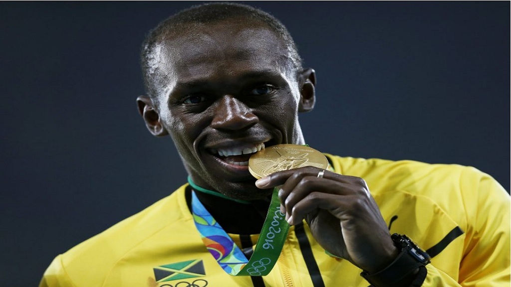 Usain Bolt bites one of his gold medals at the Rio 2016 Olympic Games.