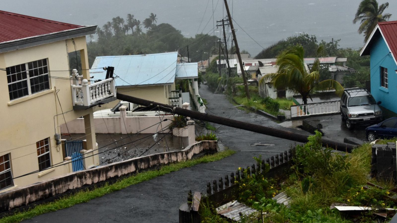 An electrical pole felled by Hurricane Elsa leans on the edge of a residential balcony, in Cedars, St Vincent, Friday, July 2, 2021.  (AP Photo/Orvil Samuel)