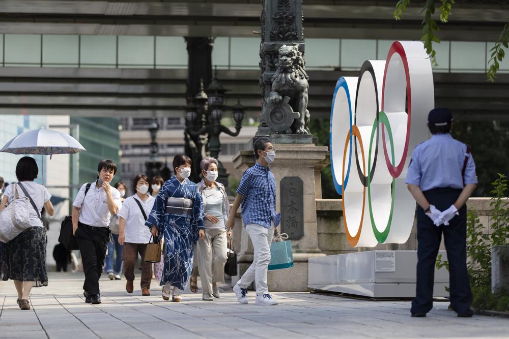 人们在2021年7月15日星期四，在东京的Nippon Bashi Bridge安装了奥林匹克戒指。（AP照片/ Hiro Komae）