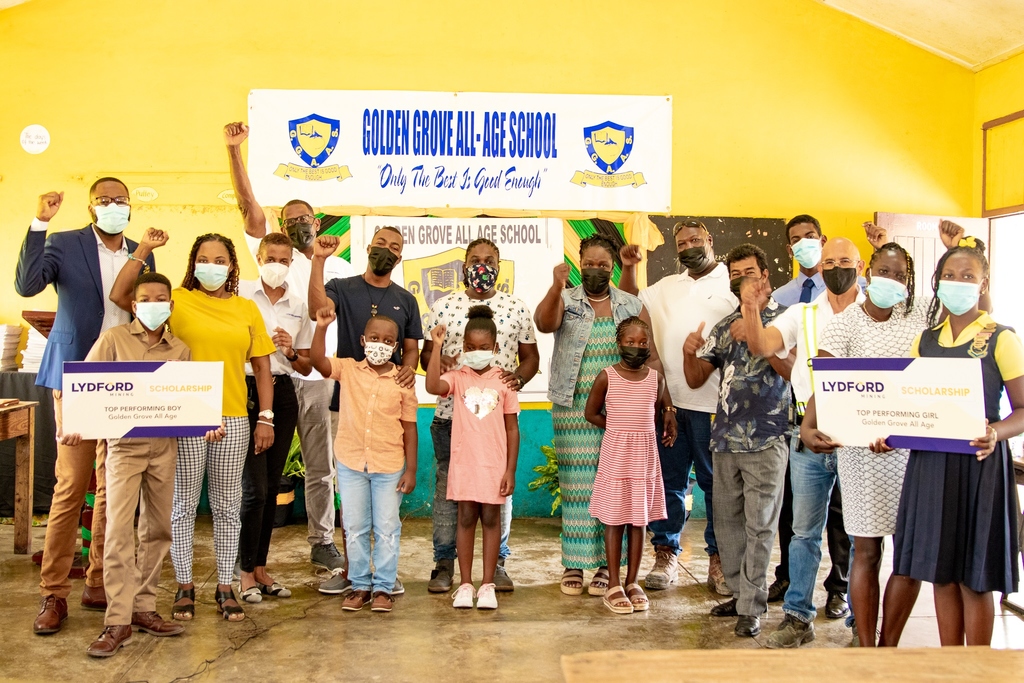  Members of the Lydford Mining Limited team and the Golden Grove All-Age School celebrate a handover of 15 scholarships. Scholarships were given to the top-performing boy and girl from the school, as well as 13 children of the St Ann-based company's employees.