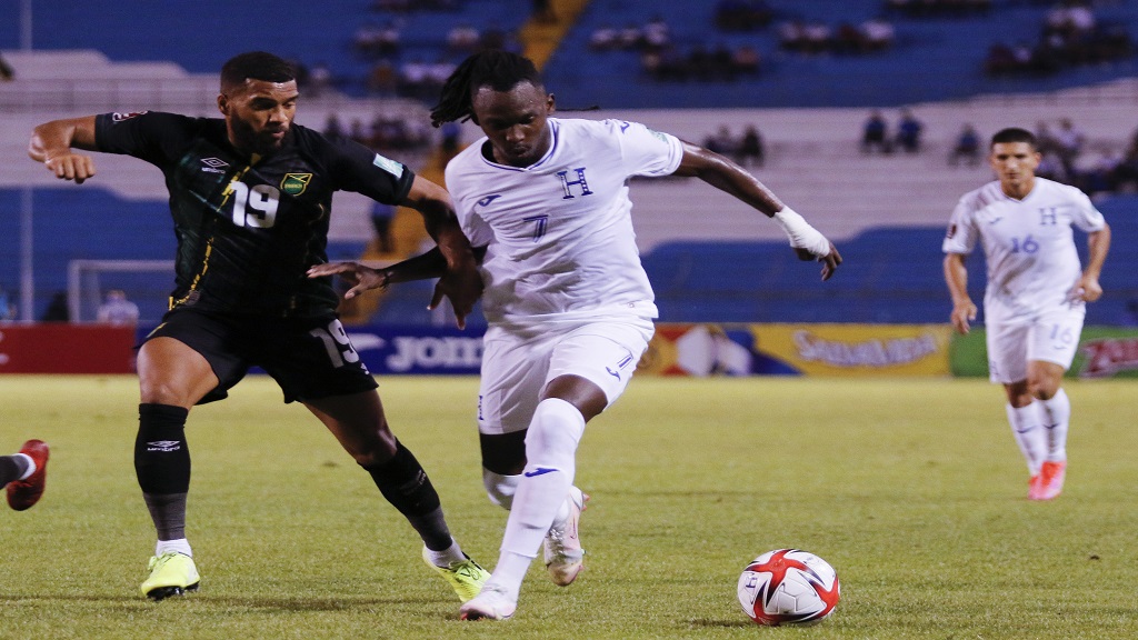 Jamaica's Adrian Mariappa, left, and Honduras' Alberth Elis compete for the ball during a qualifying football match for the FIFA World Cup Qatar 2022 at the Metropolitan Olympic stadium in San Pedro Sula, Honduras, Wednesday, Oct. 13, 2021. Jamaica won 2-0. (AP Photo/Delmer Martinez).
