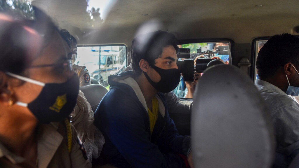 Bollywood actor Shah Rukh Khan’s son Aryan Khan, centre, escorted by law enforcement officials sits inside a vehicle outside the Narcotics Control Bureau (NCB) to appear before a court in Mumbai, India, Monday, October 4, 2021. (AP Photo)
