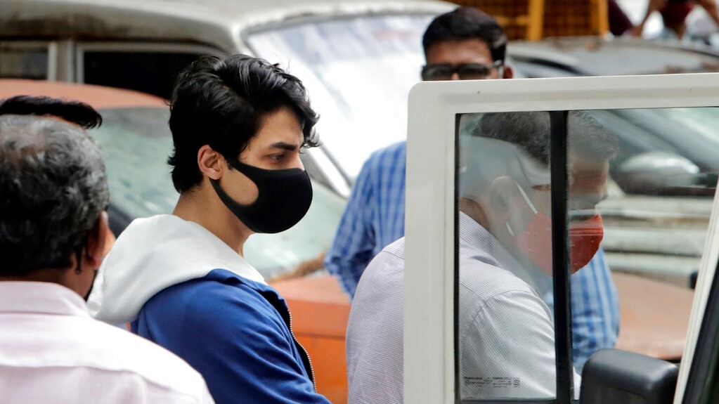 FILE- In this October 8, 2021 file photo, Bollywood actor Shah Rukh Khan's son Aryan Khan, centre, is escorted by law enforcement officials from Narcotics Control Bureau for a medical check-up, in Mumbai, India. (AP Photo/Rajanish Kakade, File)