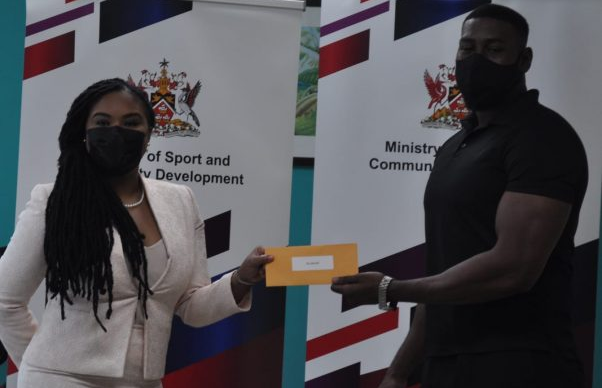 Sports Minister Shamfa Cudjoe (left) presents a cheque to boxer Nigel Paul, at a ceremony earlier in 2021. (Photo credit - Ministry of Sport and Community Development)