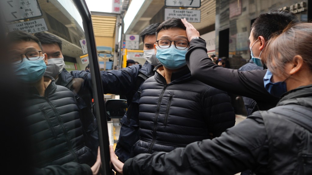 Editor of Stand News Patrick Lam, centre, is escorted by police officers into a van after they searched evidence at his office in Hong Kong, Wednesday, December 29, 2021. (AP Photo/Vincent Yu)

