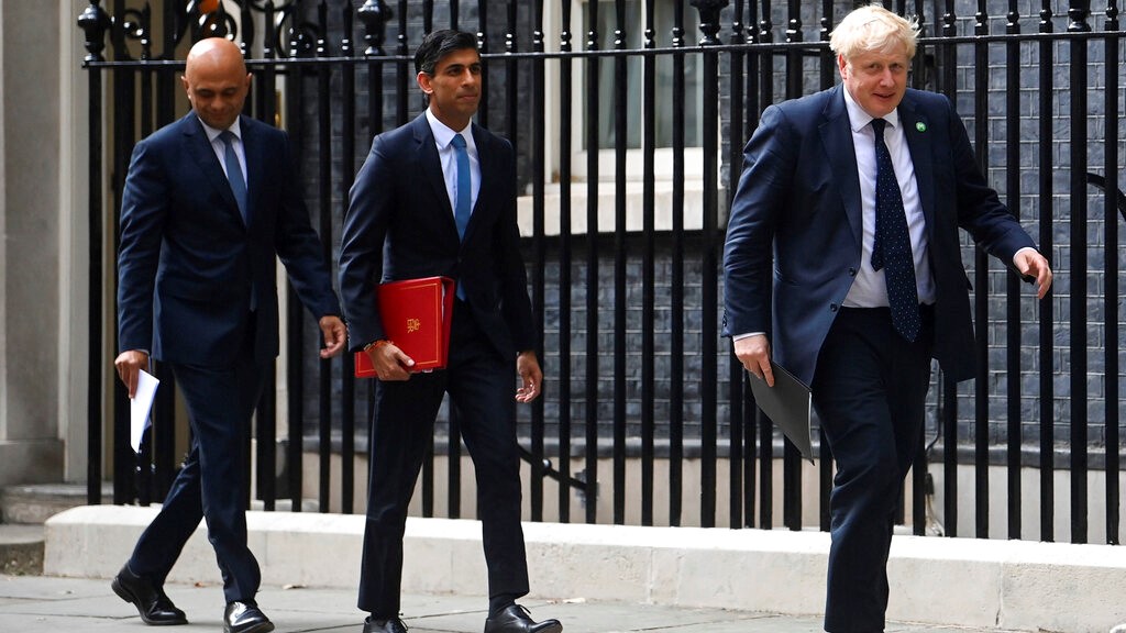 From left, British Health Secretary Sajid Javid, Chancellor of the Exchequer Rishi Sunak and Prime Minister Boris Johnson arrive at No 9 Downing Street for a media briefing on May 7, 2021. Two of Britain’s most senior Cabinet ministers have quit, a move that could spell the end of Prime Minister Boris Johnson’s leadership after months of scandals. Treasury chief Rishi Sunak and Health Secretary Sajid Javid resigned within minutes of each other. (Toby Melville/PA via AP)