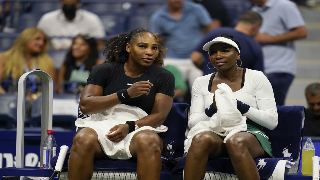 Serena Williams, left, and Venus Williams, of the United States, sit together during their first-round doubles match against Lucie Hradecká and Linda Nosková, of the Czech Republic, at the US Open tennis championships, Thursday, Sept. 1, 2022, in New York. (AP Photo/Charles Krupa).