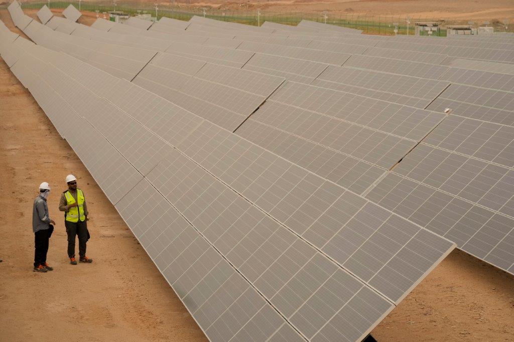 Engineers talk next to photovoltaic solar panels at Benban Solar Park, one of the world's largest solar power plant in the world, in Aswan, Egypt, October 19, 2022. (AP Photo/Amr Nabil)