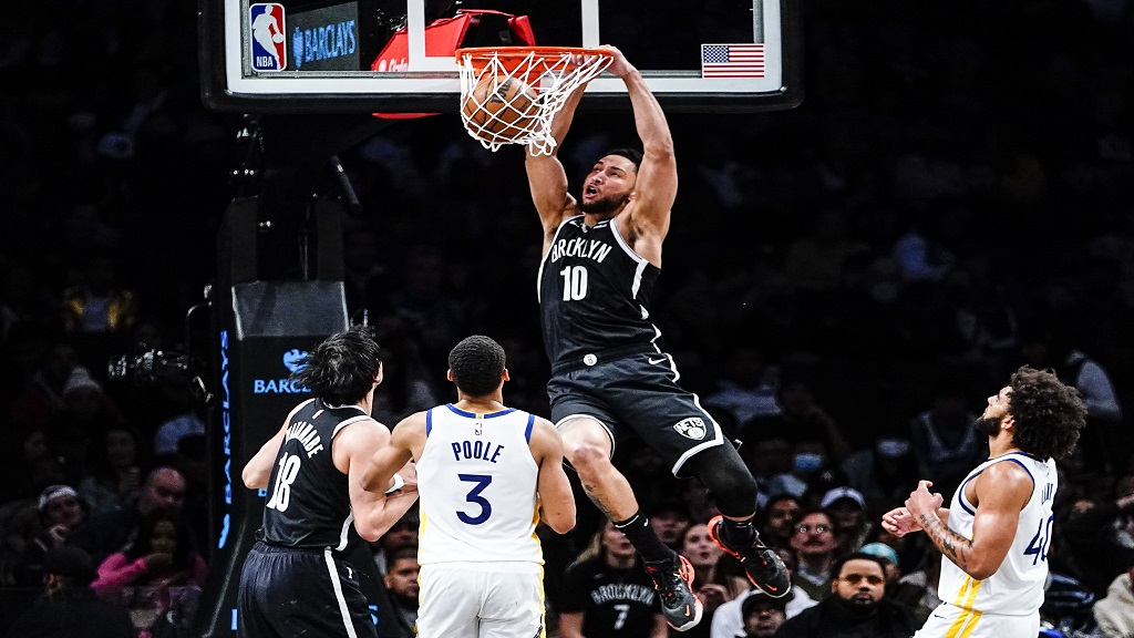 Brooklyn Nets' Ben Simmons (10) dunks the ball in front of Golden State Warriors' Jordan Poole (3) and Anthony Lamb (40) during the first half of an NBA basketball game Wednesday, Dec. 21, 2022 in New York. (AP Photo/Frank Franklin II).