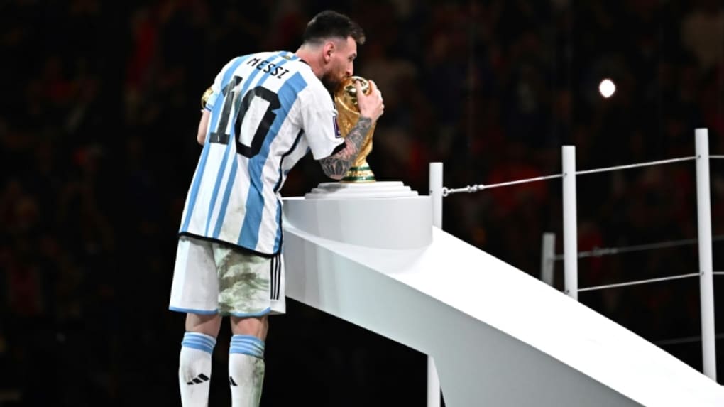 La superstar de l'Argentine Lionel Messi embrasse le trophée de la Coupe du monde après avoir été désigné meilleur joueur de la compétition, le 18 décembre 2022 à Doha
