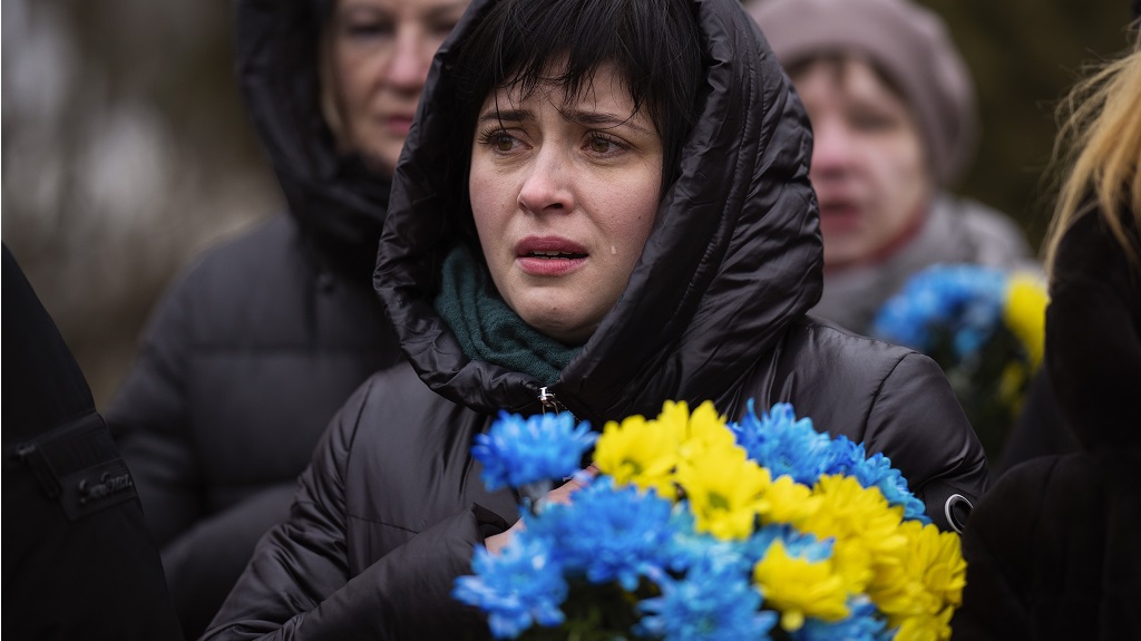 A woman cries during a memorial service to mark the one-year anniversary of the start of the Russia Ukraine war, in a cemetery in Bucha, Ukraine, Friday, Feb. 24, 2023. (AP Photo/Emilio Morenatti)