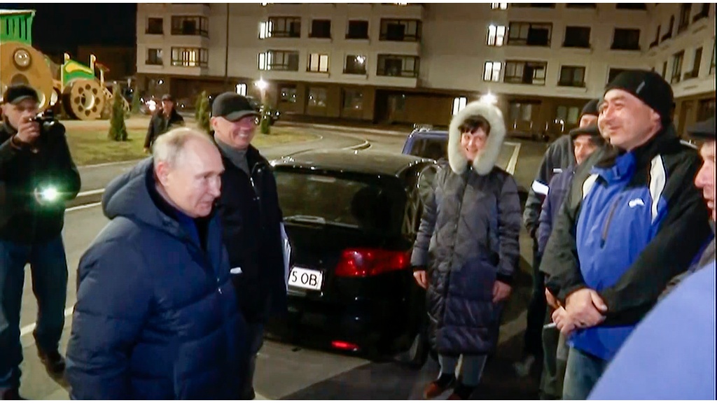In this photo taken from video released by Russian TV Pool on Sunday, March 19, 2023, Russian President Vladimir Putin talks with local residents during his visit to Mariupol in Russian-controlled Donetsk region, Ukraine. (Pool Photo via AP) 