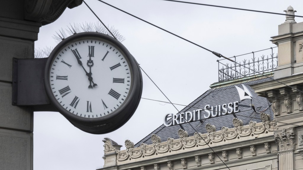 Five to twelve "fuenf vor zwoelf" is written on a clock next to a logo of the Swiss bank Credit Suisse, in Zurich, Switzerland, Monday, March 20, 2023. (Ennio Leanza/Keystone via AP) 