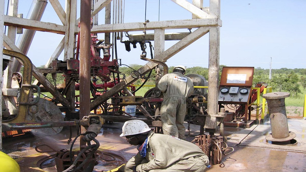 FILE —Chadian workers guide a pipe down a well in the Doba oil fields in southern Chad Oct. 10, 2003.  (AP Photo/Susan Linnee, File)