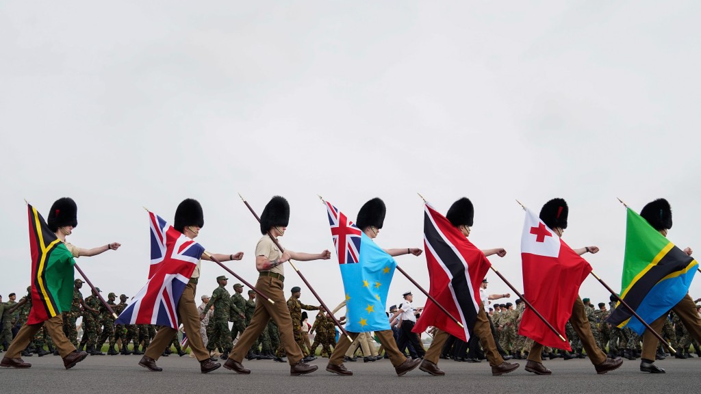  FILE - Guards carry flags from Commonwealth countries during a full tri-service and Commonwealth rehearsal at RAF Odiham in Hook, England, Sunday, April 30, 2023, ahead of their involvement in the second procession that accompanies King Charles III and Queen Camilla from Westminster Abbey back to Buckingham Palace. (Andrew Matthews/PA via AP, File)