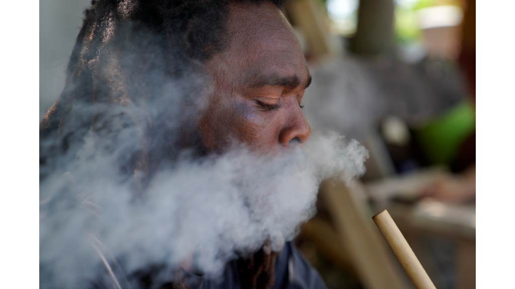 Ras Richie, a member of the Ras Freeman Foundation for the Unification of Rastafari, smokes cannabis from a chalice pipe on Saturday, May 13, 2023, in Liberta, Antigua. (AP Photo/Jessie Wardarski)