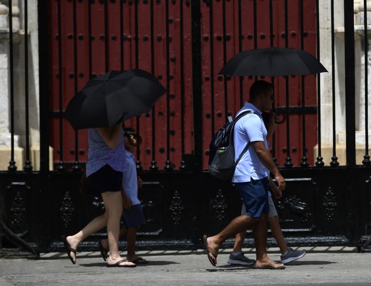 Pedestrians shelter from the sun under umbrellas during a heat wave, July 10, 2023 in Seville, Spain AFP  