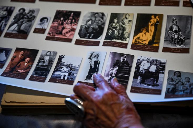 Kathryn Red Corn, ex-diretora do Osage Nation Museum, mostra fotos dos primeiros membros da tribo Osage a receber títulos petrolíferos após a ordem executiva de 1906 © CHANDAN KHANNA / AFP