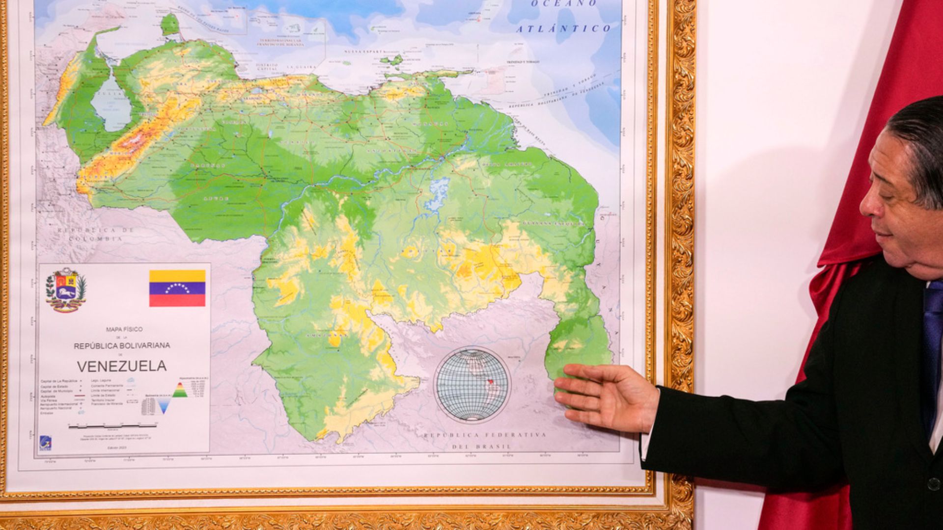 Chairman of the Special Commission for the Defense of Guyana Essequibo Hermann Escarra, stands next to Venezuela's new map that includes the Essequibo territory during an unveiling ceremony in Caracas, Venezuela, Friday, December 8, 2023. (AP Photo/Matias Delacroix)