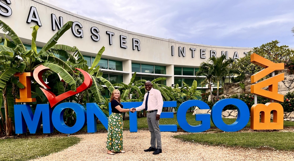 Carolina Coto, senior communication manager for Uber in the Caribbean and Central America and Gregg Connell, President of the Montego Bay Maxi Taxi Association pose for a photo in front of the Montego Bay signage at the Sangster International Airport. Uber Taxi is a collaboration between Uber and the Montego Bay-based Maxi Taxi Association. 