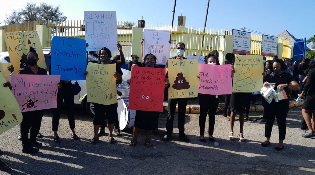 Teachers at Greater Portmore High bearing placards, protesting the stench from a nearby sewage plant. 