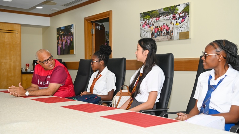 CIBC Caribbean International Bank, Chief Executive Officer, Mark St. Hill engages some of the students during the Bank’s International Women’s Day 2024 event for secondary school children. From left, Tyra Taitt of The Ellerslie School; Nadia Zhang, Harrison College; and Trashana Hinds of The St Michael School.