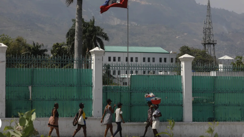  People walk past the National Palace in Port-au-Prince, Haiti on March 25, 2024. (AP Photo/Odelyn Joseph)