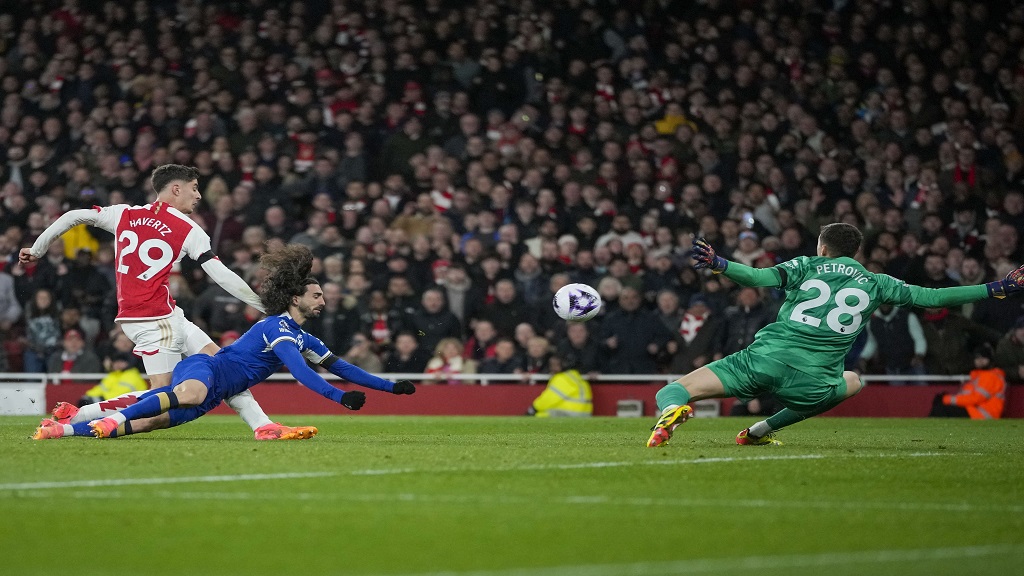  Arsenal's Kai Havertz, left, scores his side's third goal during the English Premier League football match against Chelsea at Emirates Stadium in London, Tuesday, April 23, 2024. (AP Photo/Kin Cheung).