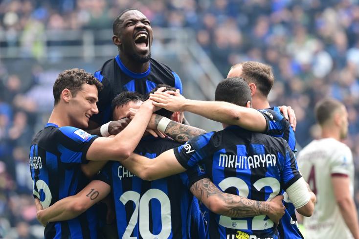Inter midfielder Hakan Calhanoglu congratulated by his teammates after his second goal against Torino on April 28, 2024 at San Siro PIERO CRUCIATTI / AFP  