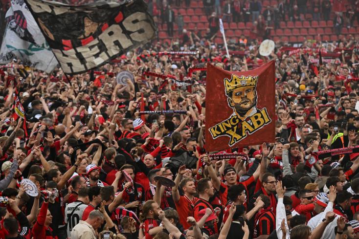 Supporters of Bayer Leverkusen football club celebrate their club's victory in the German championship after its 5-0 victory against Werder Bremen at the Leverkusen stadium on April 14, 2024. INA FASSBENDER / AFP 