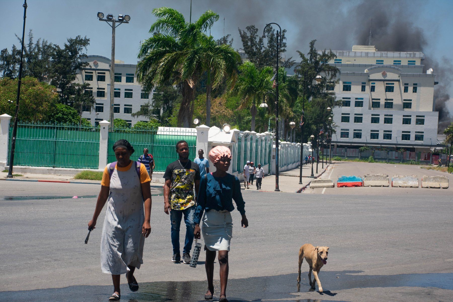 Smoke escapes from a Ministry of Finance building, as residents leave the area after hearing gunfire, on April 2, 2024 in Port-au-Prince, Haiti CLARENS SIFFROY / AFP  