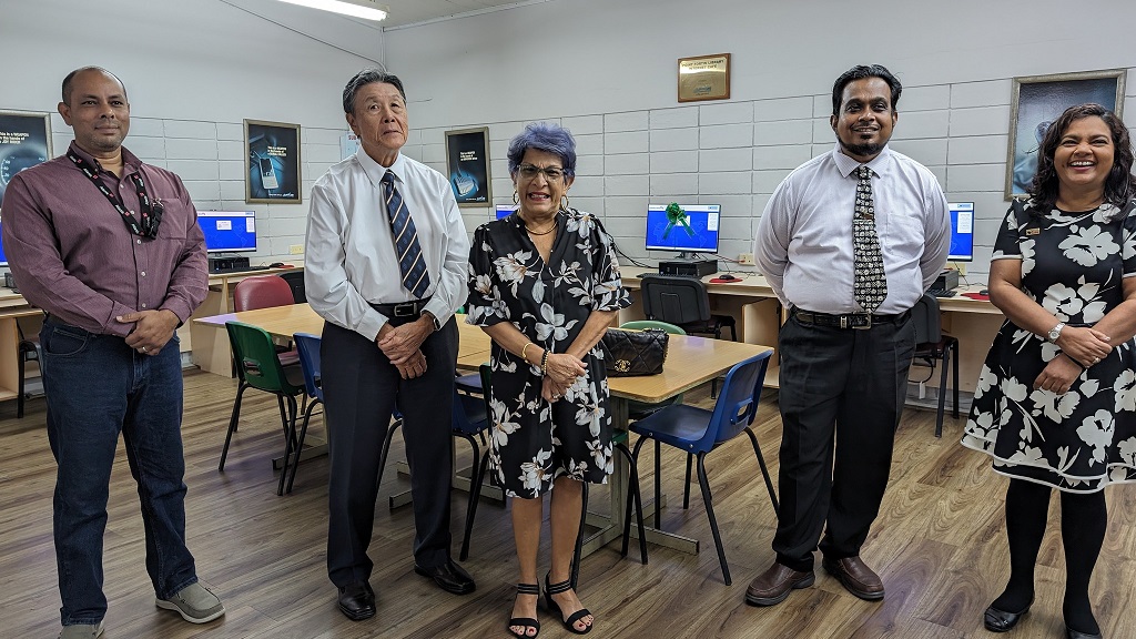 Dr John Chin Yuen Kee and wife Sandra Chin Yuen Kee pose for a photo with staff at NALIS, following the donation of 11 desktop computers to the Point Fortin Library. Photo: NALIS
