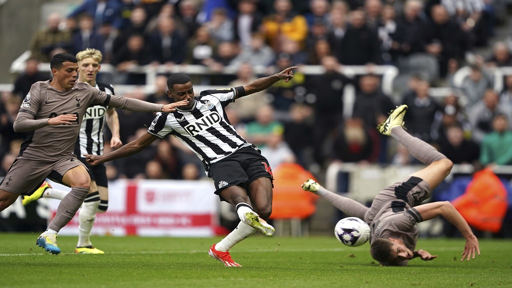 Newcastle United's Alexander Isak, centre, scores the opening goal during the English Premier League football match againstTottenham Hotspur at St. James' Park in Newcastle, England, Saturday, April 13, 2024. (Owen Humphreys/PA via AP).
