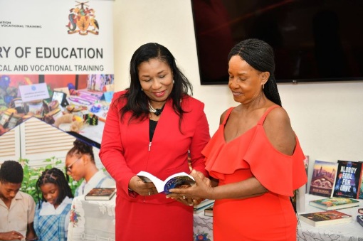 Chairman of the National Task Force on Literacy Education, Dr. Sylvia Henry (left), and Dr. Astra Babb of Babb’s Reading Clinic reading one of the donated books. (Ministry of Education, Technological and Vocational Training)