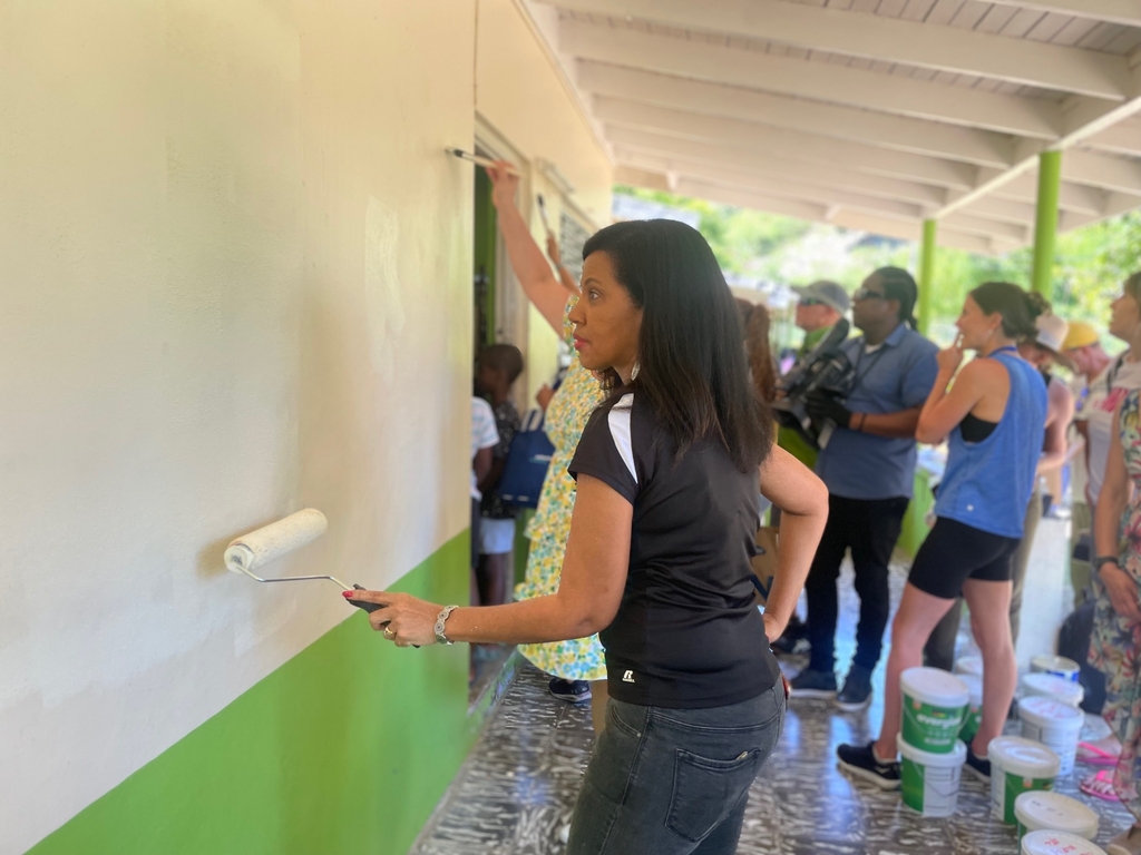 CHTA President Nicola Madden-Greig assists with painting at the SOS Children's Village in Barrett Town, St James. (Photo: Shamille Scott)