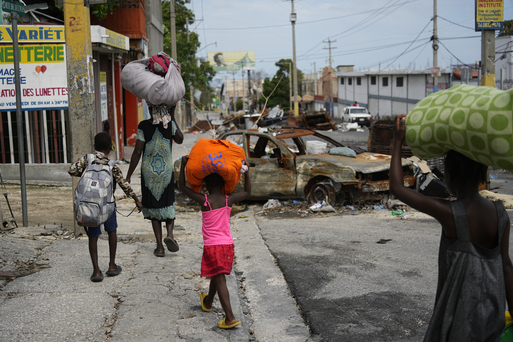  Residents walk past road blocks as they evacuate the Delmas 22 neighbourhood to escape gang violence in Port-au-Prince, Haiti, Thursday, May 2, 2024. (AP Photo/Ramon Espinosa)