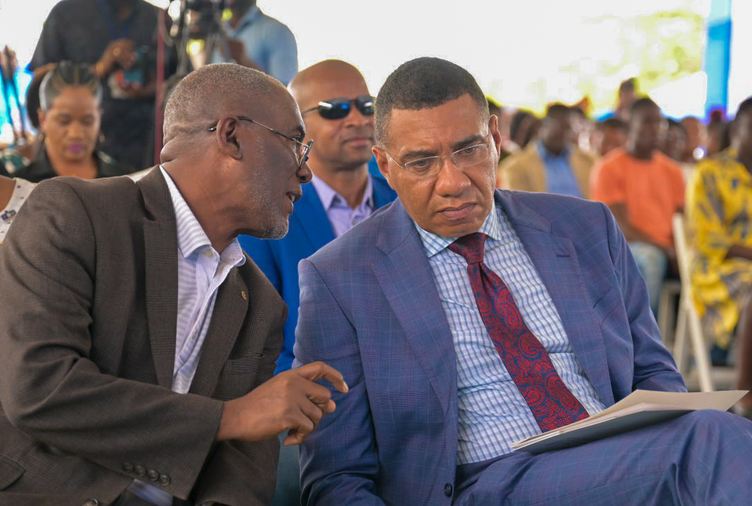 Prime Minister, Andrew Holness (right), converses with National Housing Trust (NHT) Chairman, Linval Freeman, during the official handover of residential serviced lots under the new Friendship Oaks Phase 1 development in Goshen, St Elizabeth. 