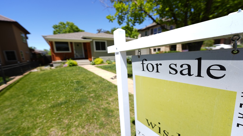 A for sale sign stands outside a single-family residence on Wednesday, May 22, 2024, in southeast Denver. Policymakers' willingness to keep their key rate at a two-decade peak — thereby keeping costs painfully high for mortgages, auto loans and other forms of consumer borrowing — carries its own risks. (AP Photo/David Zalubowski)

