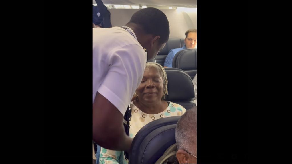 Pilot Jerome Lawrence shares a sweet moment with his mother during a recent United flight. Image taken from video. 