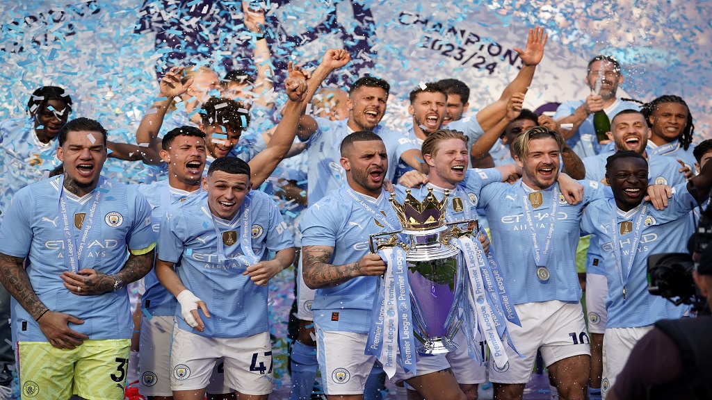 Manchester City players celebrate with the Premier League trophy after the English Premier League football match against West Ham United at the Etihad Stadium in Manchester, England, Sunday, May 19, 2024. Manchester City clinched the English Premier League on Sunday after beating West Ham in their last match of the season. (AP Photo/Dave Thompson).


