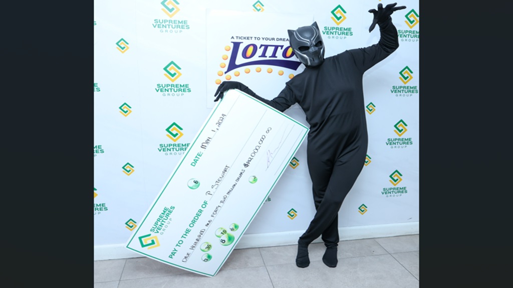 P Stewart basking in the thrill of a $142-million Lotto jackpot win at the presentation event in St Andrew.