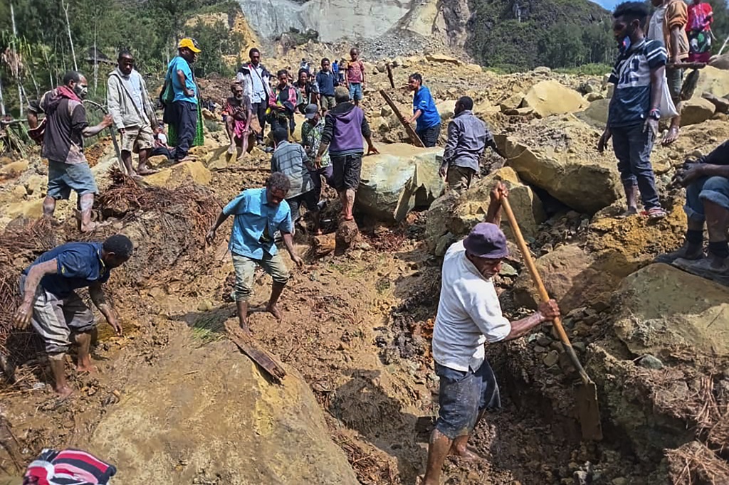 Villagers search through a landslide in Yambali, in the Highlands of Papua New Guinea, Sunday, May 26, 2024. (Mohamud Omer/International Organization for Migration via AP)