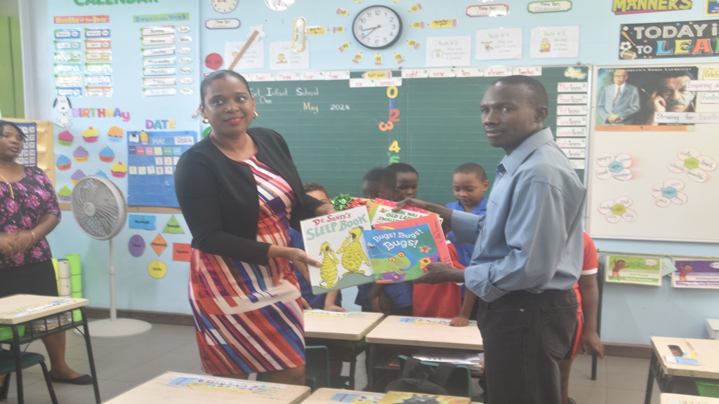 Donalyn Constantine (left) receiving books from Choix Melchoir (right) on behalf of the school