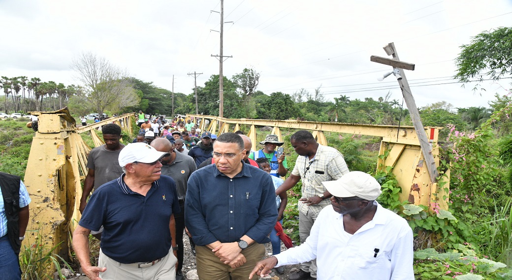 Prime Minister, Andrew Holness (centre), in discussion with Jamaica Broilers (JB) Group Chairman, Robert Levy (left), and Member of Parliament for St Catherine South Western, Everald Warmington (right), during a recent visit to Spring Village in St Catherine.