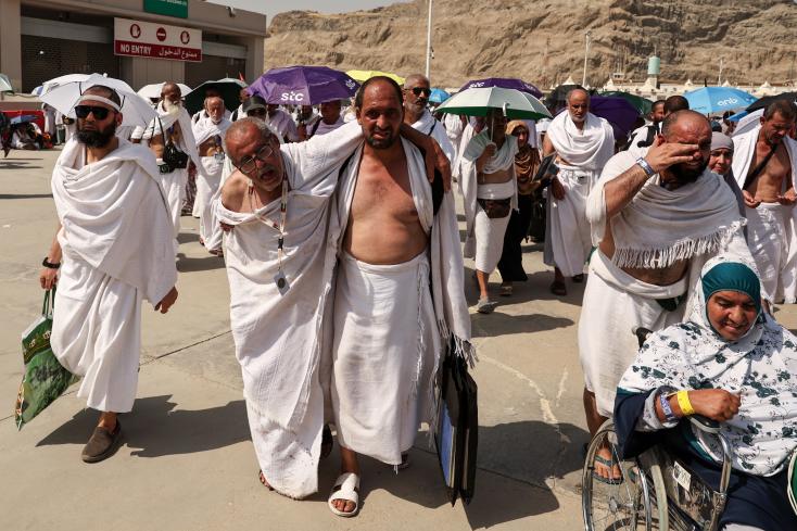 A man suffering from the scorching heat is helped by a pilgrim during the hajj in Mina, near Mecca, on June 16, 2024 in Saudi Arabia AFP Fadel Senna 